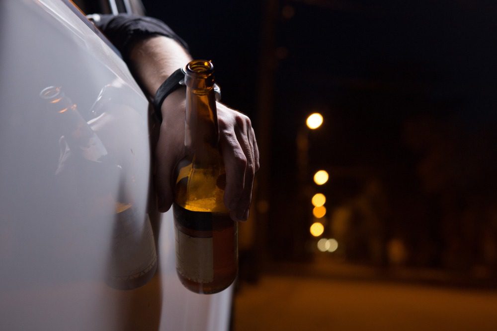 Drunk Driving Car Accident Attorneys in Georgia | FREE Consultation Man is consuming alcohol while driving his car.