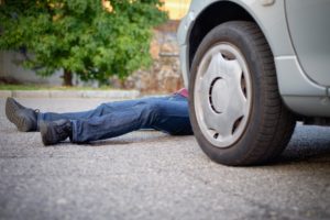 close-up of pedestrian on ground in front of a car