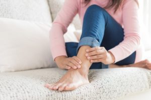 woman with ankle pain on sofa